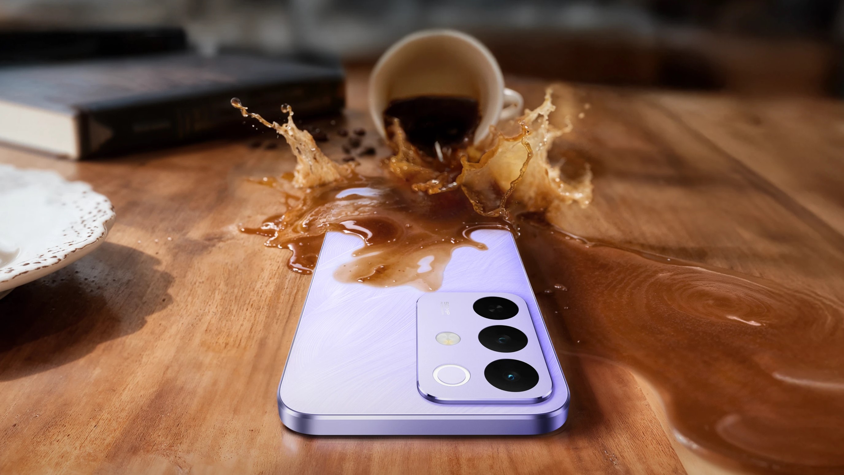Сиреневый смартфон Realme C85 Pro лежит на деревянном столе и на него проливают кофе.